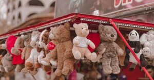 Vibrant plush toy display on city street vendor stall with urban background.